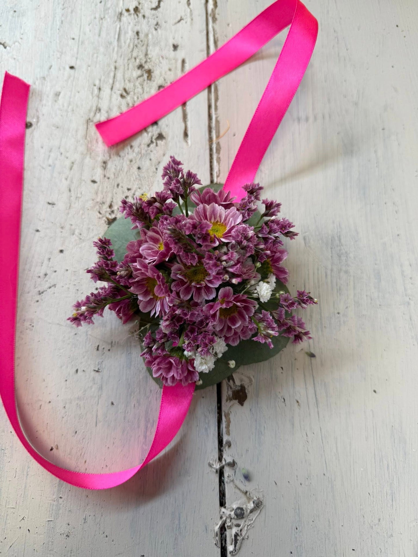 Bracciale floreale visto di lato, con disposizione elegante dei fiori e colori vivaci per matrimoni o feste.