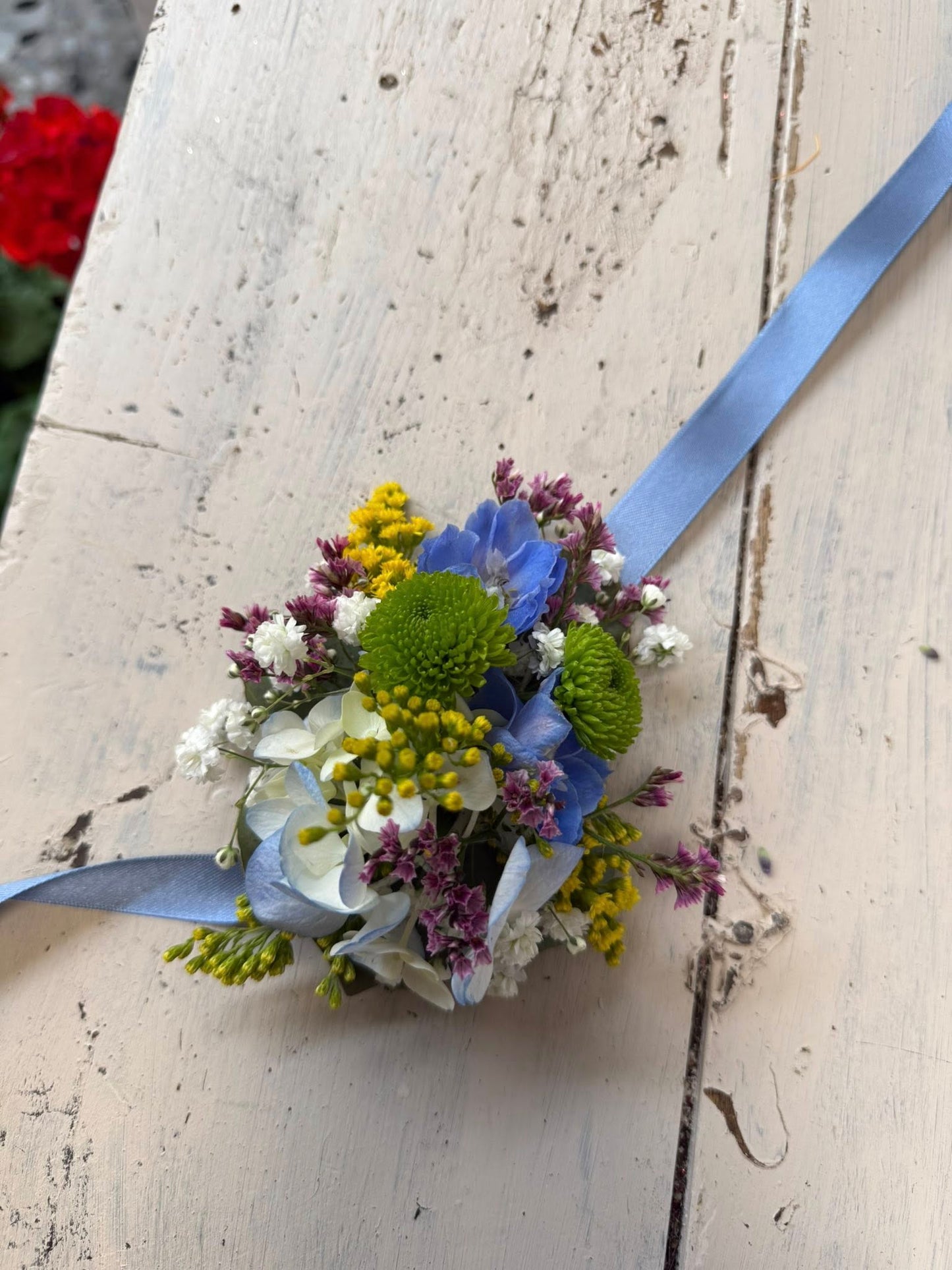 Dettaglio dei fiori colorati del bracciale, evidenziando la freschezza e la composizione armoniosa.
