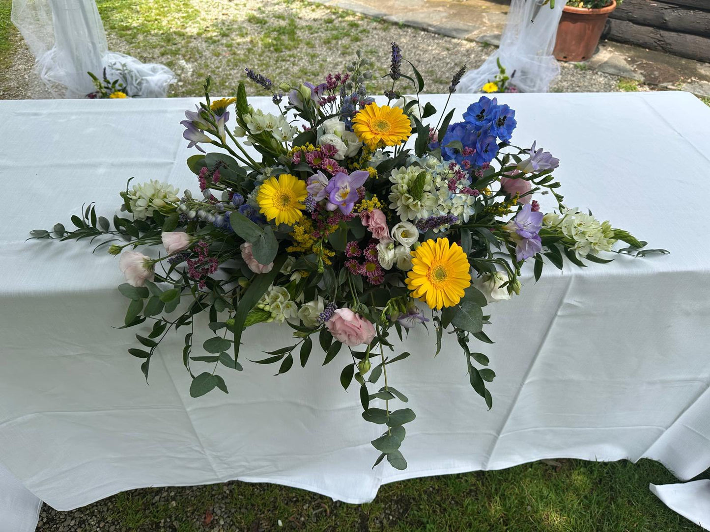 Composizione floreale di circa 55x45 cm, personalizzabile con fiori freschi di stagione. Ideale per matrimoni, eventi e celebrazioni, adattabile a tavoli e tema dell’evento.