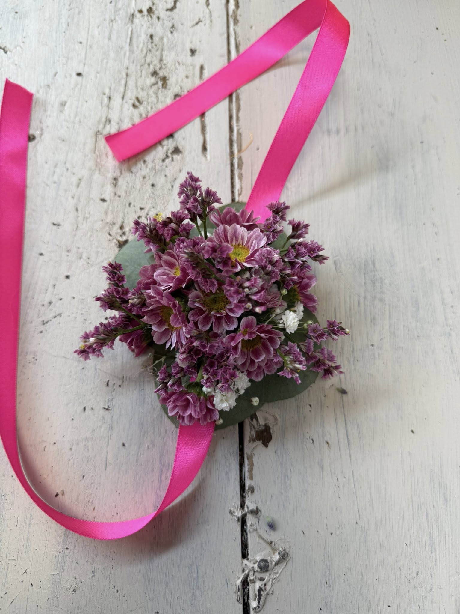 Bracciale floreale visto di lato, con disposizione elegante dei fiori e colori vivaci per matrimoni o feste.
