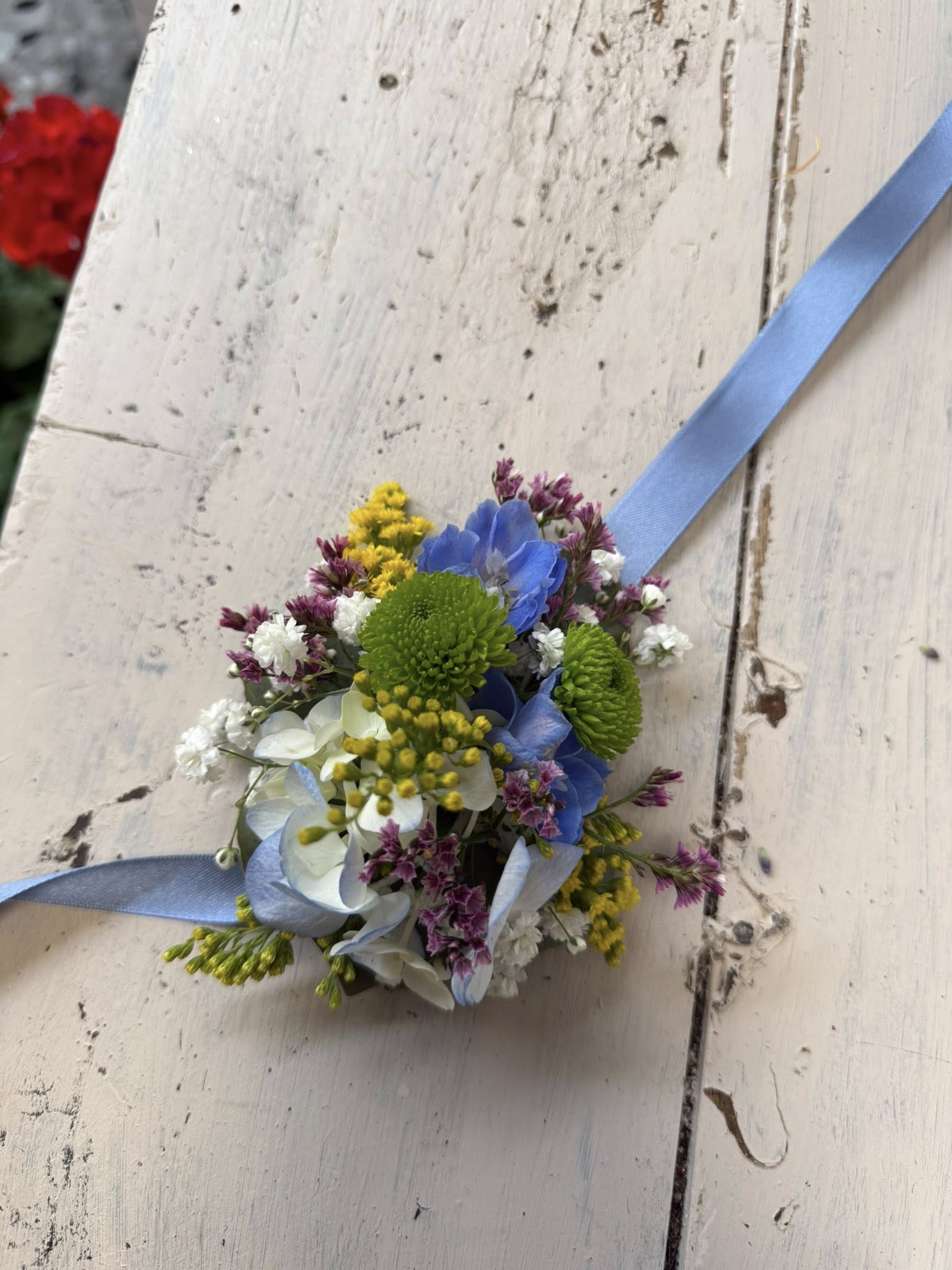 Dettaglio dei fiori colorati del bracciale, evidenziando la freschezza e la composizione armoniosa.