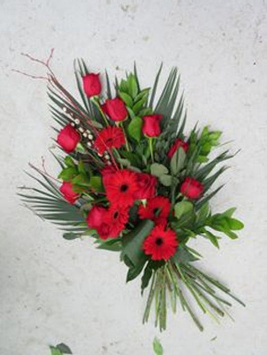 Composizione floreale sobria e delicata con fiori freschi di giornata, personalizzabile con nastri e biglietto commemorativo, ideale come omaggio funebre.