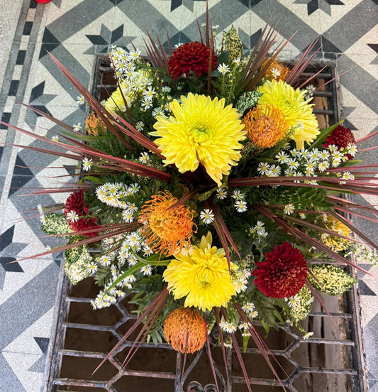 Composizione floreale funebre con fiori freschi, realizzata su misura per cerimonie commemorative.