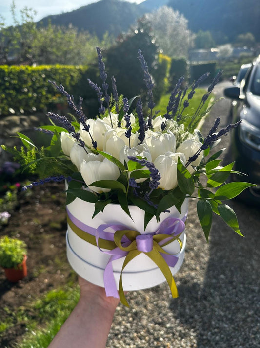 Scatola rotonda bianca (raggio 25 cm) con tulipani e lavanda freschi. Composizione elegante e stagionale, ideale come centrotavola, regalo o decorazione, con fiori freschi di alta qualità e scatola riutilizzabile.
